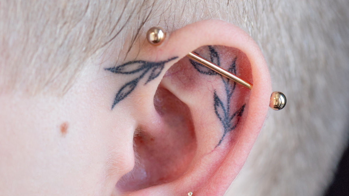  A healed industrial piercing with a straight barbell crossing the upper ear