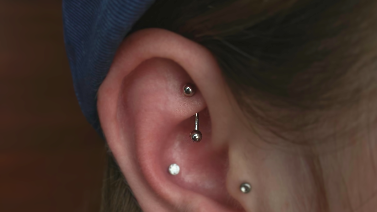 rook piercing with a curved barbell through the inner fold of the ear