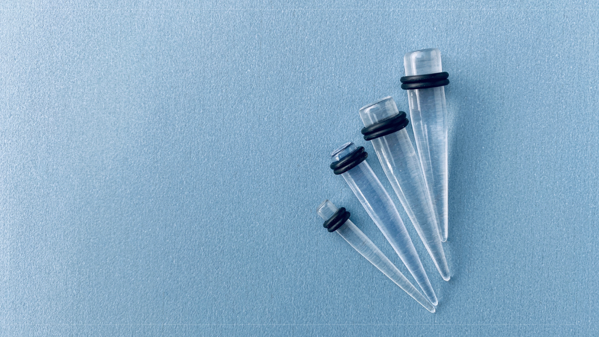 Ear stretching plugs and tunnels laid out in order of increasing size