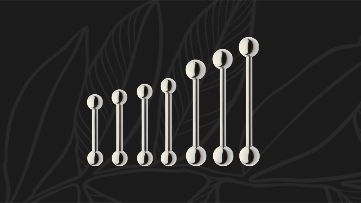 A long starter barbell beside a shorter healed-length barbell for a tongue piercing